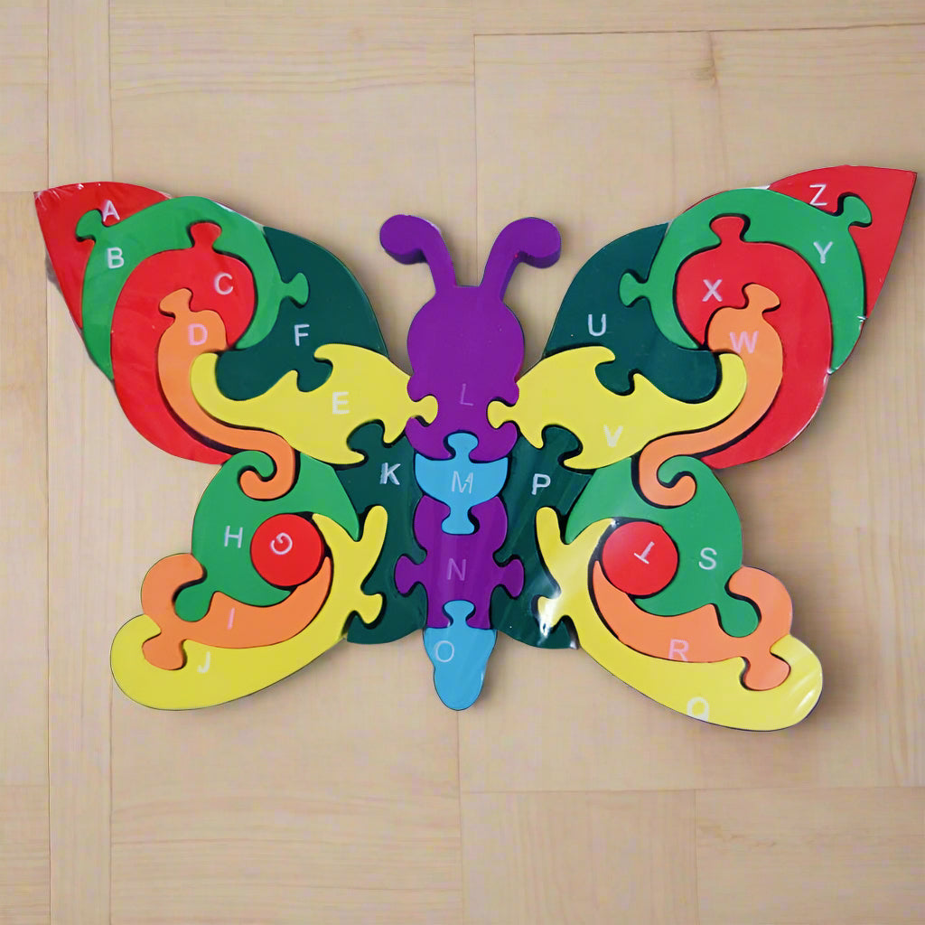 Colorful butterfly-shaped puzzle with letters on a wooden surface